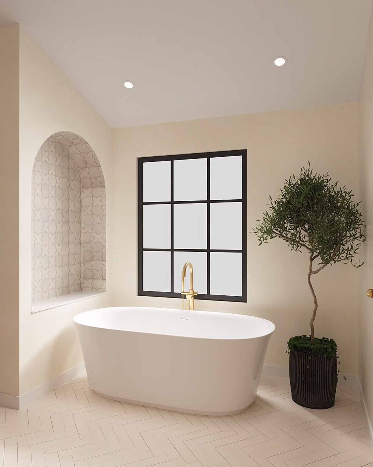 Spa-inspired bathroom featuring freestanding soaking tub with gold faucet and olive tree accent
