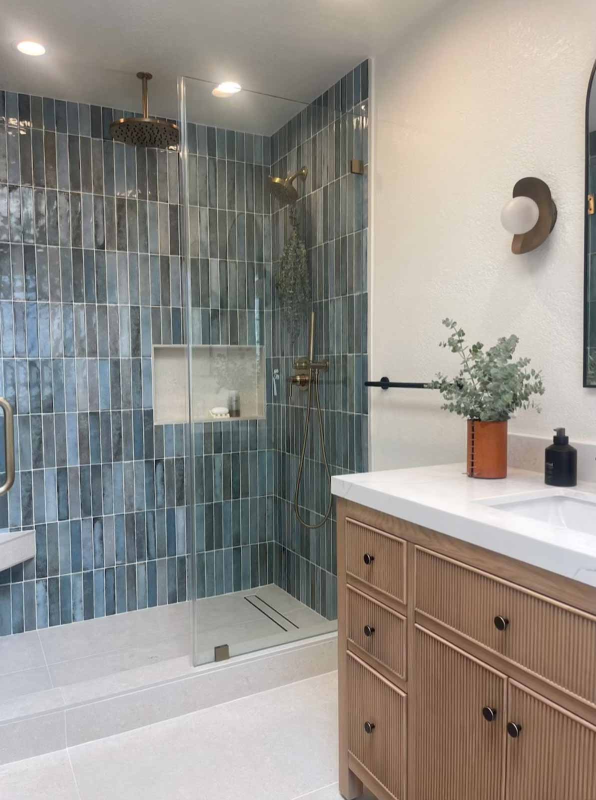 Glendale bathroom remodel with blue subway tile walk-in shower, brass rain showerhead, and glass enclosure