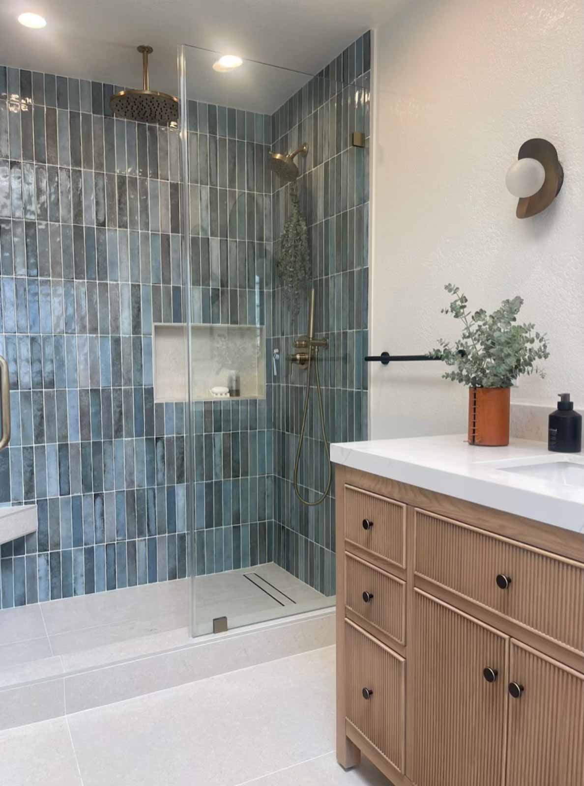 Blue tile shower with oak vanity and modern sconce lighting - Glendale bathroom renovation