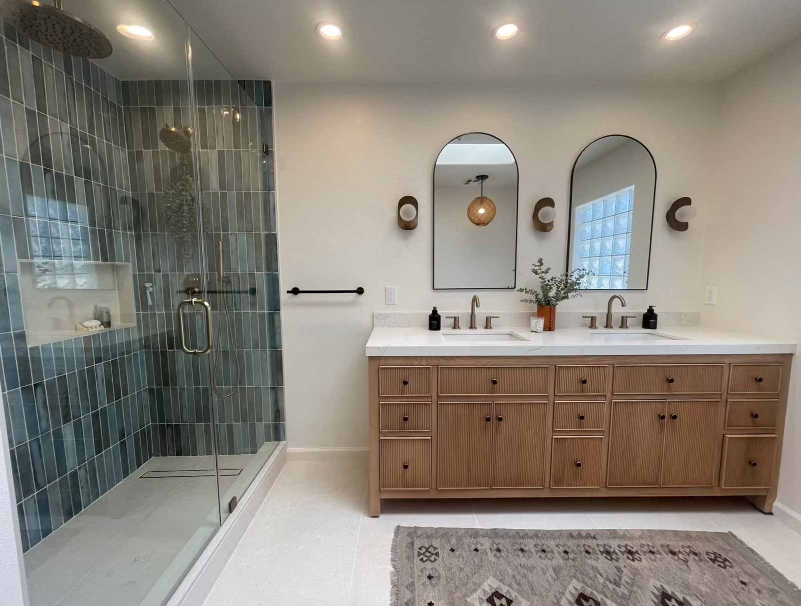 Spacious Glendale master bath with double vanity, blue tile shower, and geometric area rug