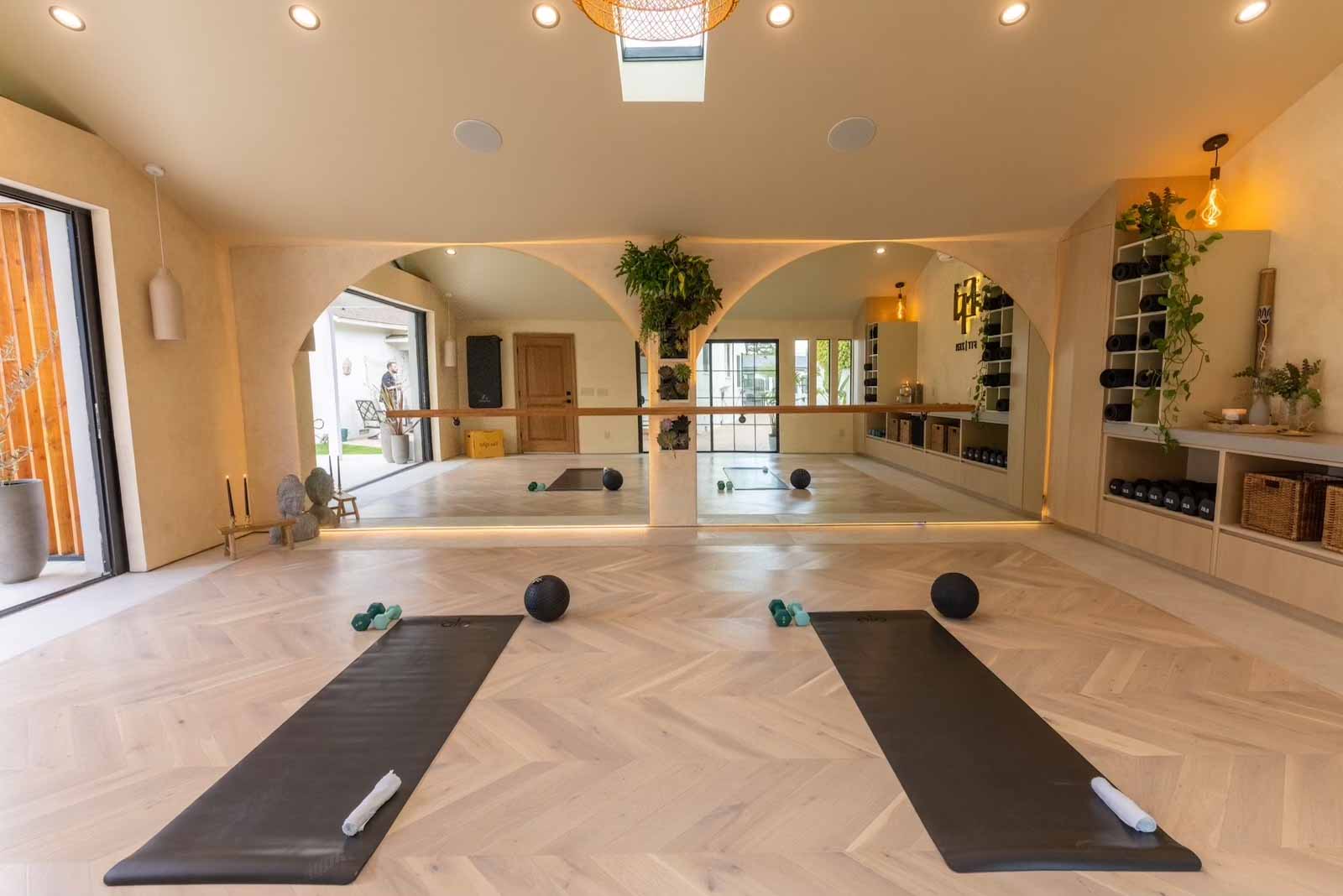 Studio featuring three arched mirrors with ballet barre and plants