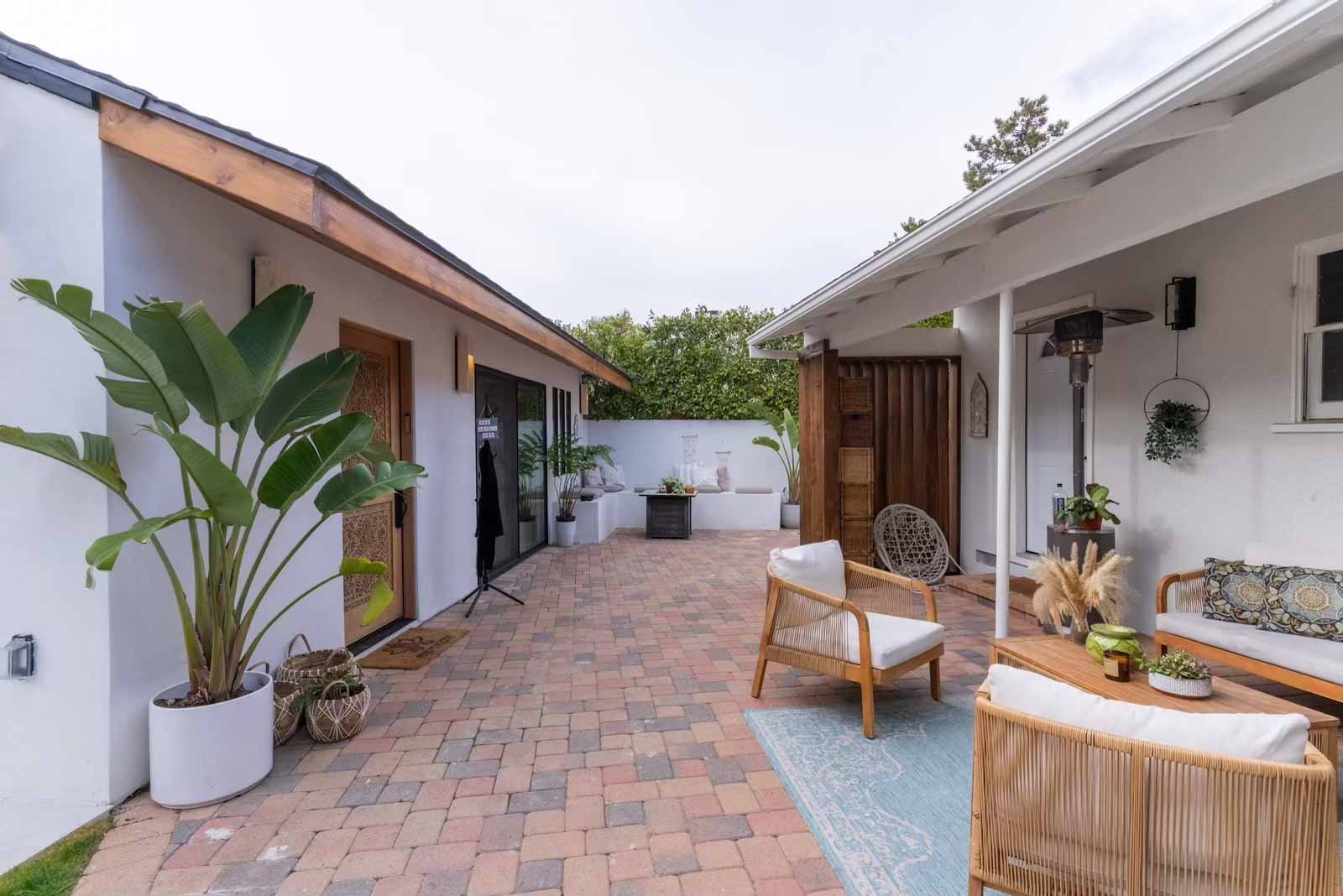 Full view of ADU and main house with paver patio and outdoor furniture