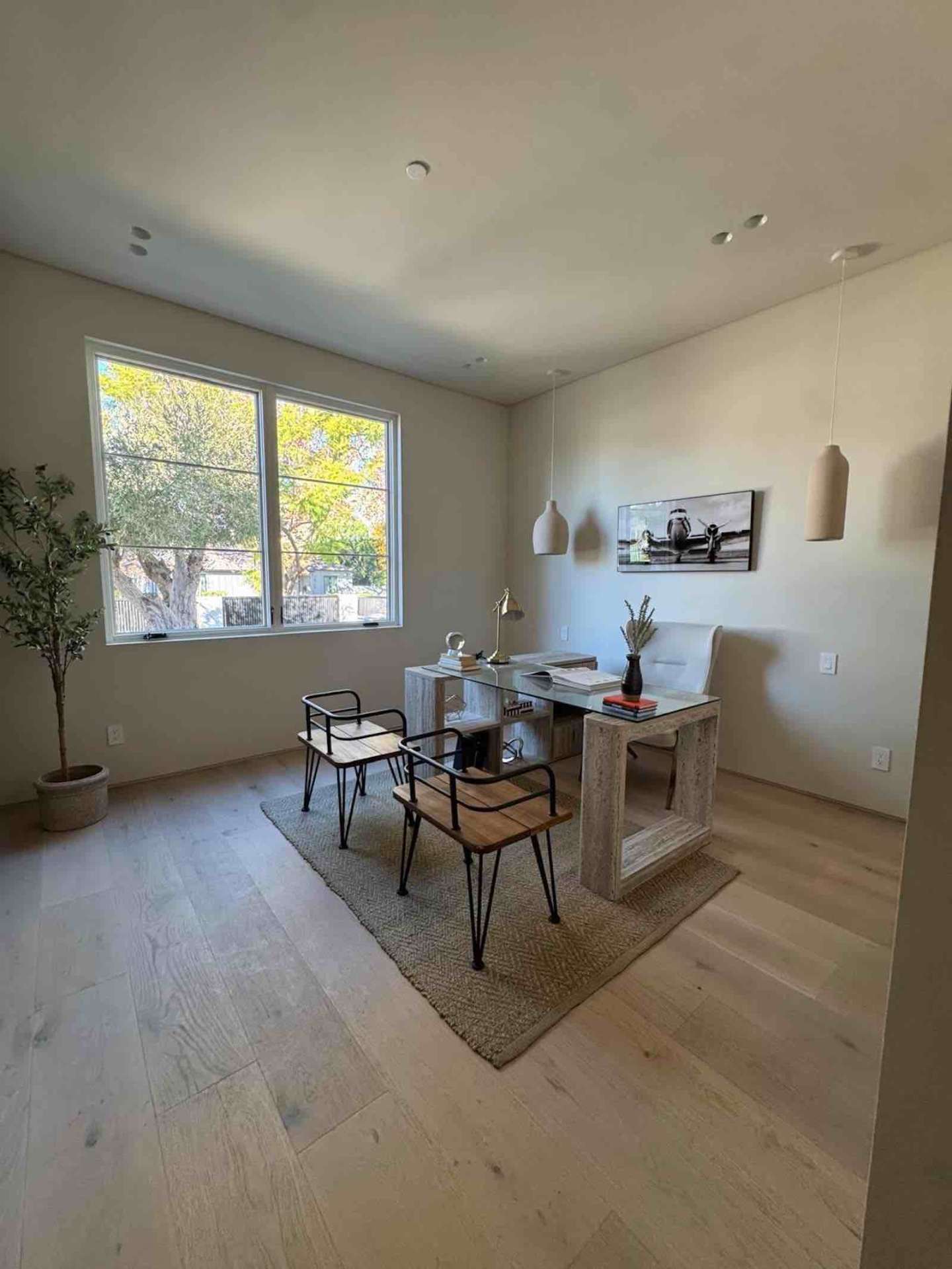Encino ADU home office with stone desk, ceramic pendants, wide-plank oak floors, and olive tree