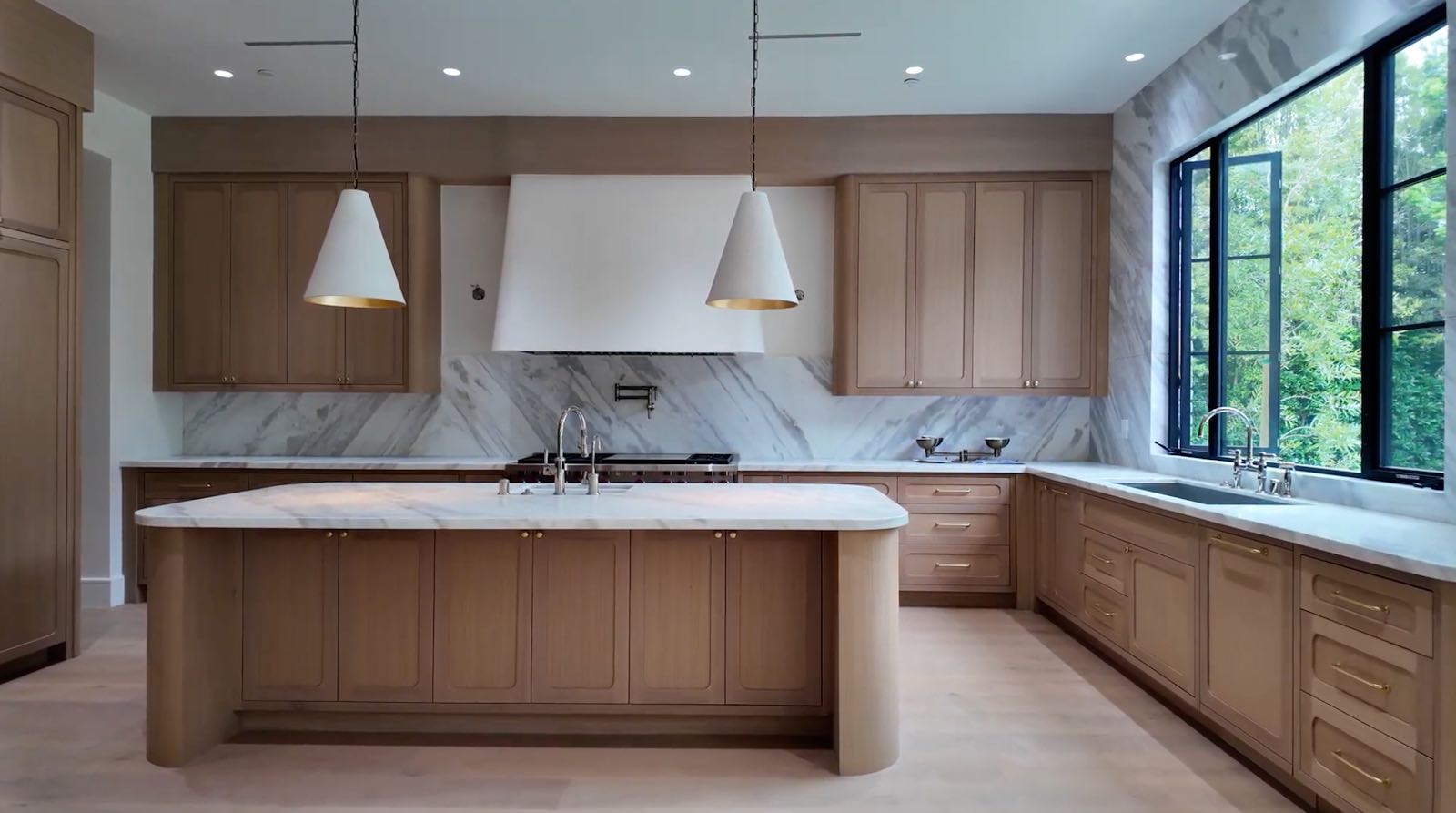 Brentwood kitchen full view with island pendant lights and garden window