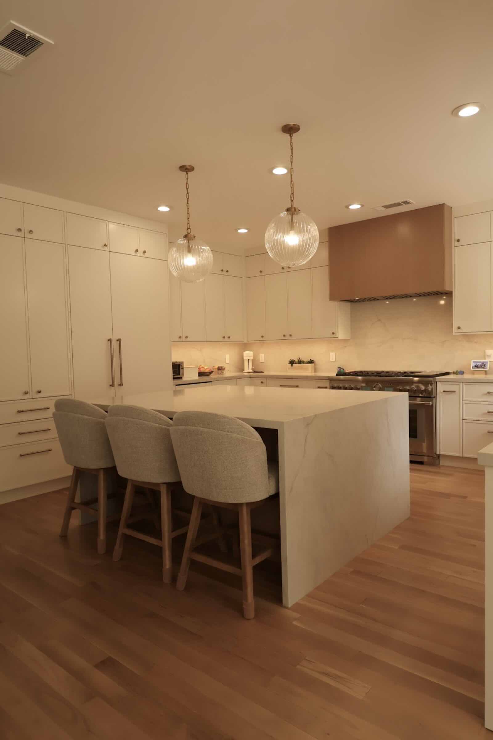 La Cañada Flintridge kitchen island seating with hardwood floors and range beyond