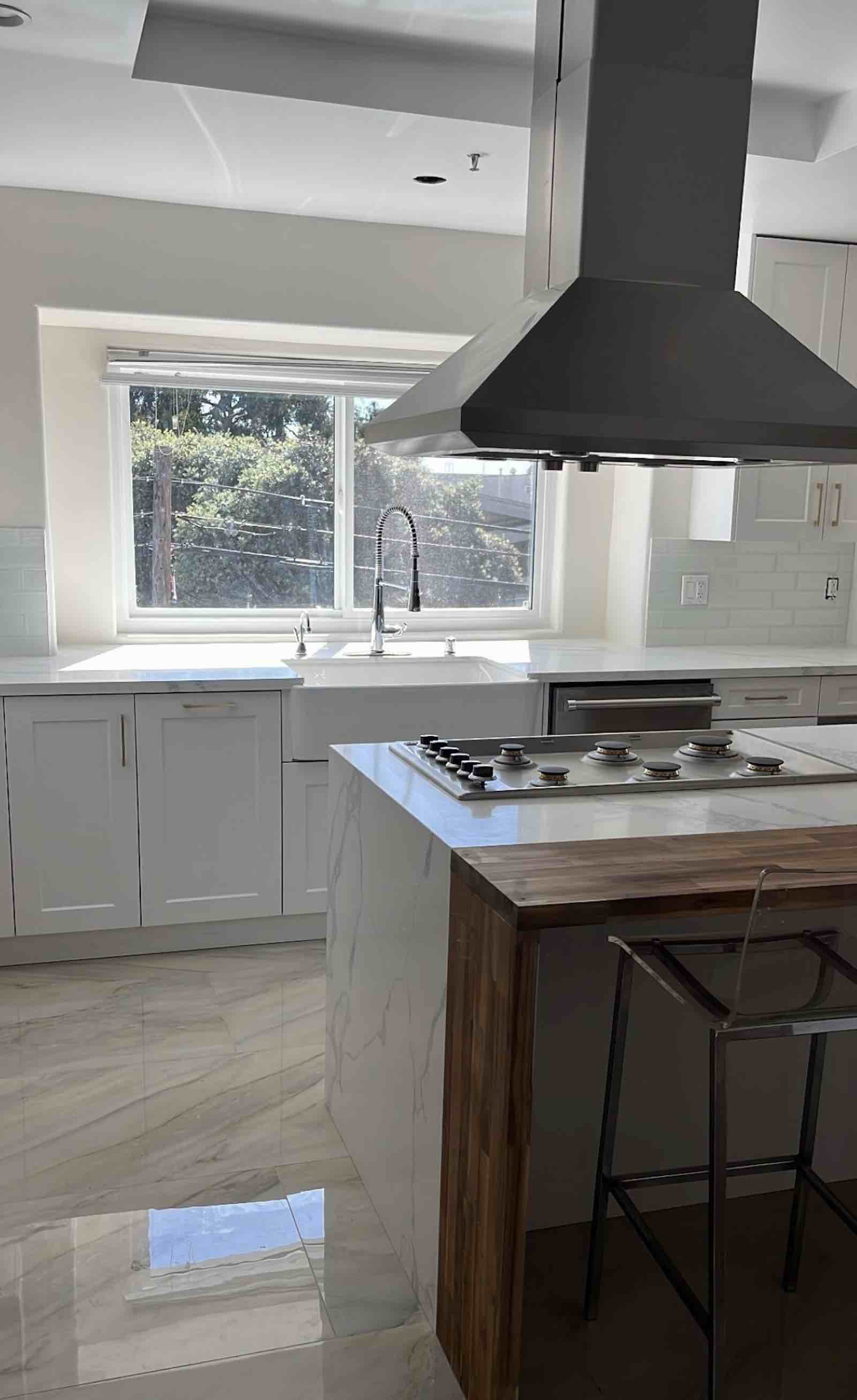Santa Monica kitchen farmhouse sink, white cabinetry, and stainless range hood