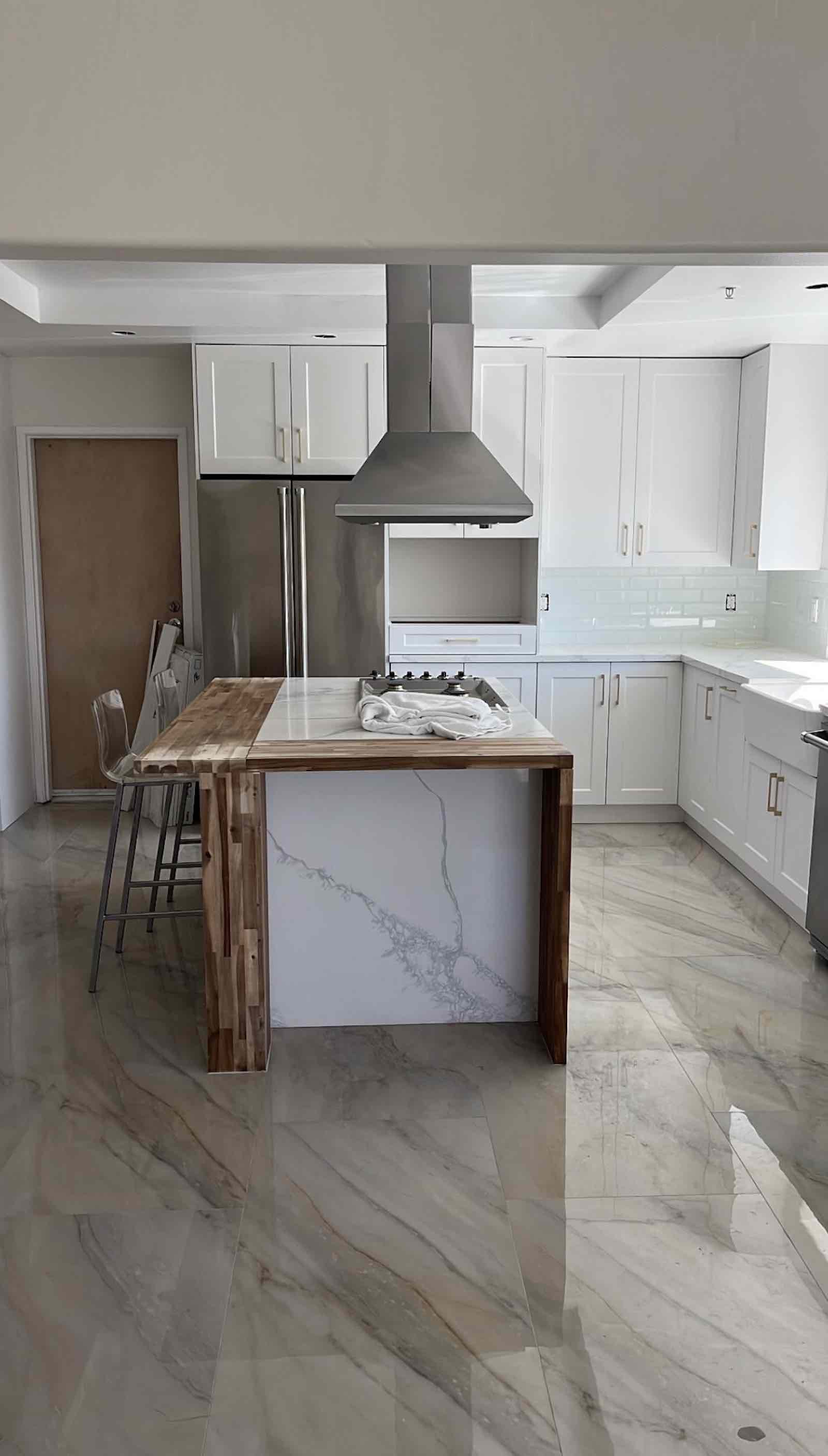 Santa Monica kitchen full view with marble-look floors and walnut island seating