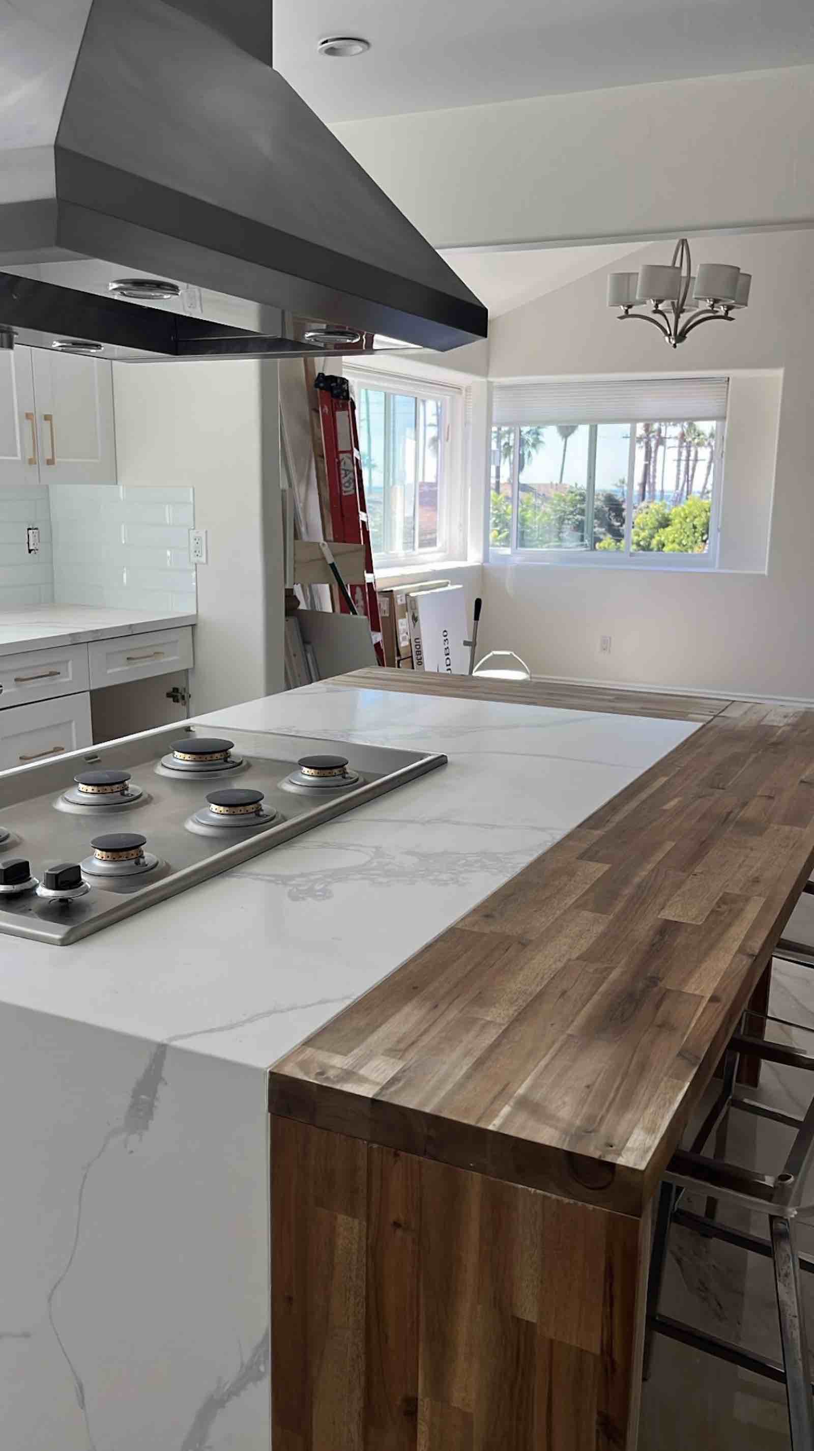 Santa Monica kitchen island with quartz cooktop, walnut bar, and ocean-view windows