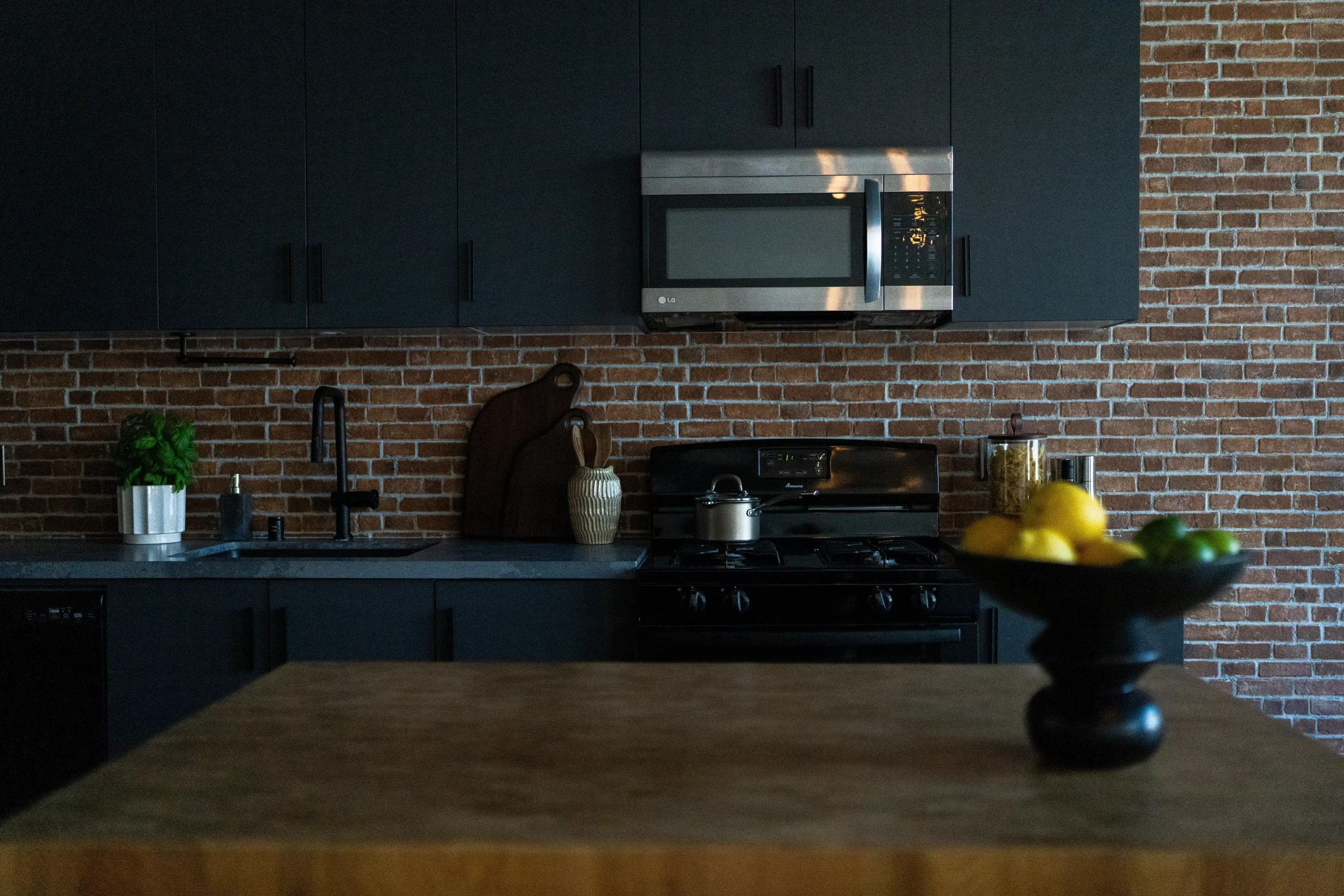 Dark vibe kitchen with brick walls remodeled by New Dawn Construction