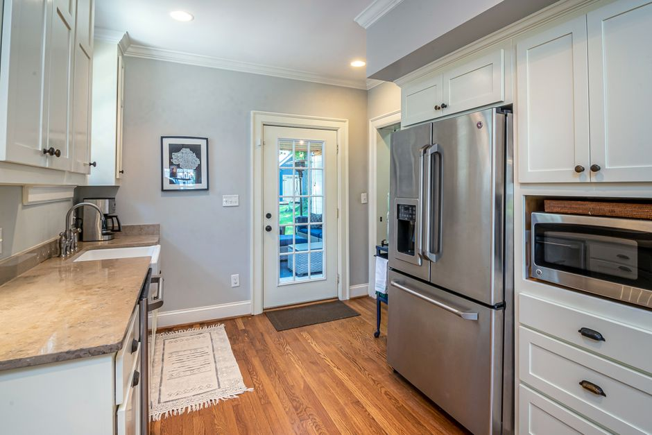 A kitchen showing an open refrigerator and
dishwasher with visible aisle space around them.