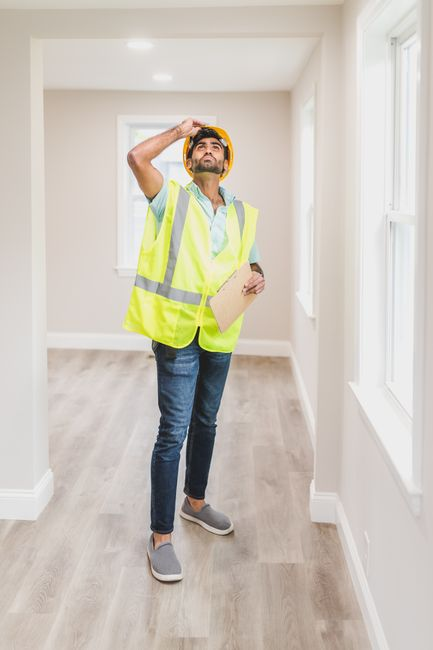 Contractor examining exposed wall framing during a 
home renovation.